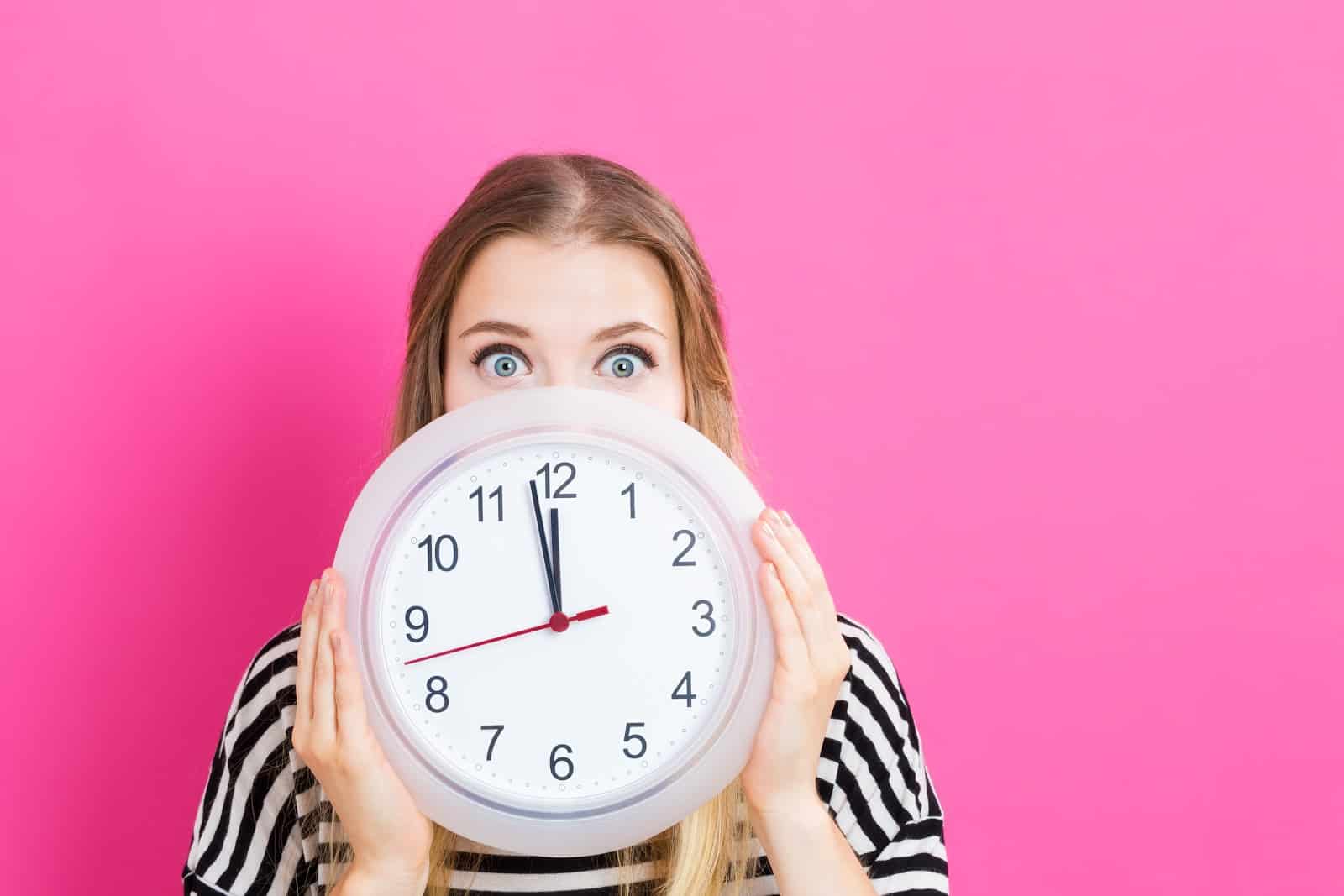 woman holding a clock wondering where the time has gone